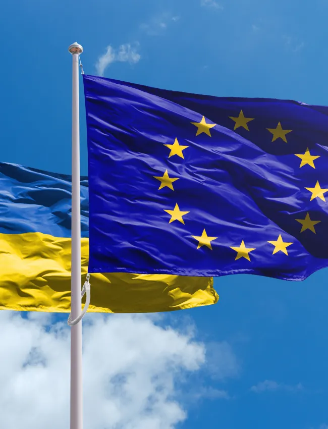 Ukraine and EU flags above blue sky. Ukraine path towards Europe Union