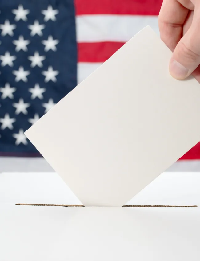 Close up of white ballot box with American flag in the background during US Midterm Congressional Elections 2026.